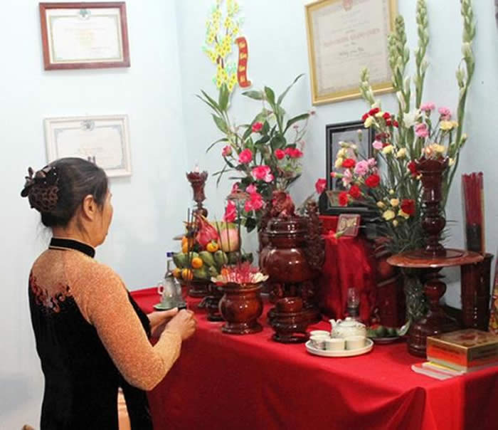 Thắp hương trên bàn thờ gia tiên thể hiện lòng 
thành kính của con cháu đối với ông bà tổ tiên